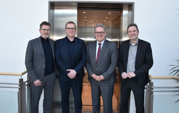 Die Geschäftsführer des its und von AKE vor einem Aufzug der Firma