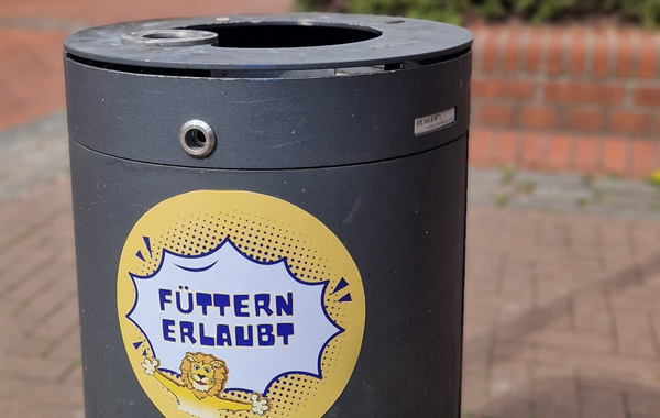 Füttern erlaubt-Aufkleber auf einem Mülleimer