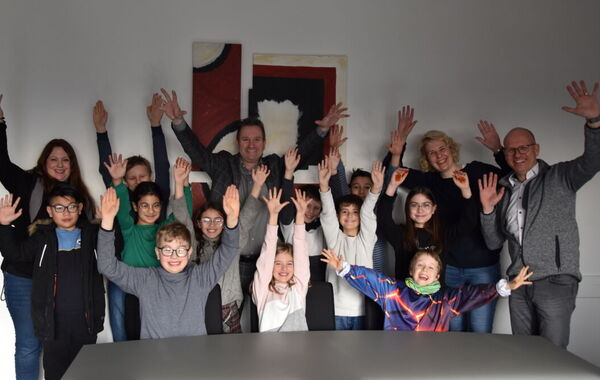 Kinder der Grengrachtschule mit ihren Lehrkräften und Bürgermeister Pierre Froesch winken.