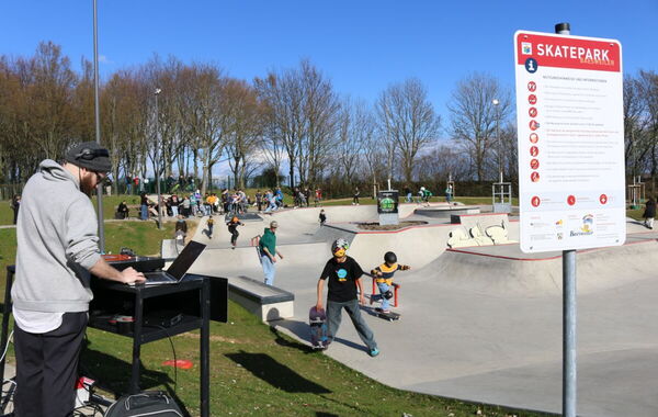 Skater fahren auf dem Skate-Platz des Sport- und Bürgerparks. Ein DJ legt Musik auf.