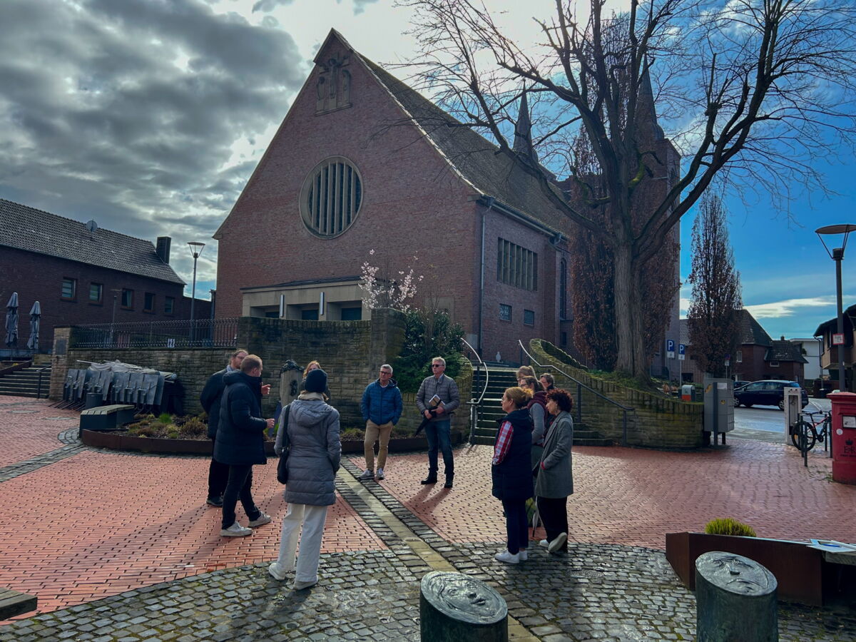Bürger*innen stehen auf dem Kirchvorplatz