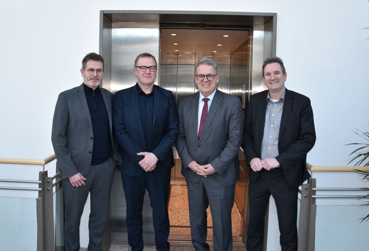 Die Geschäftsführer des its und von AKE vor einem Aufzug der Firma