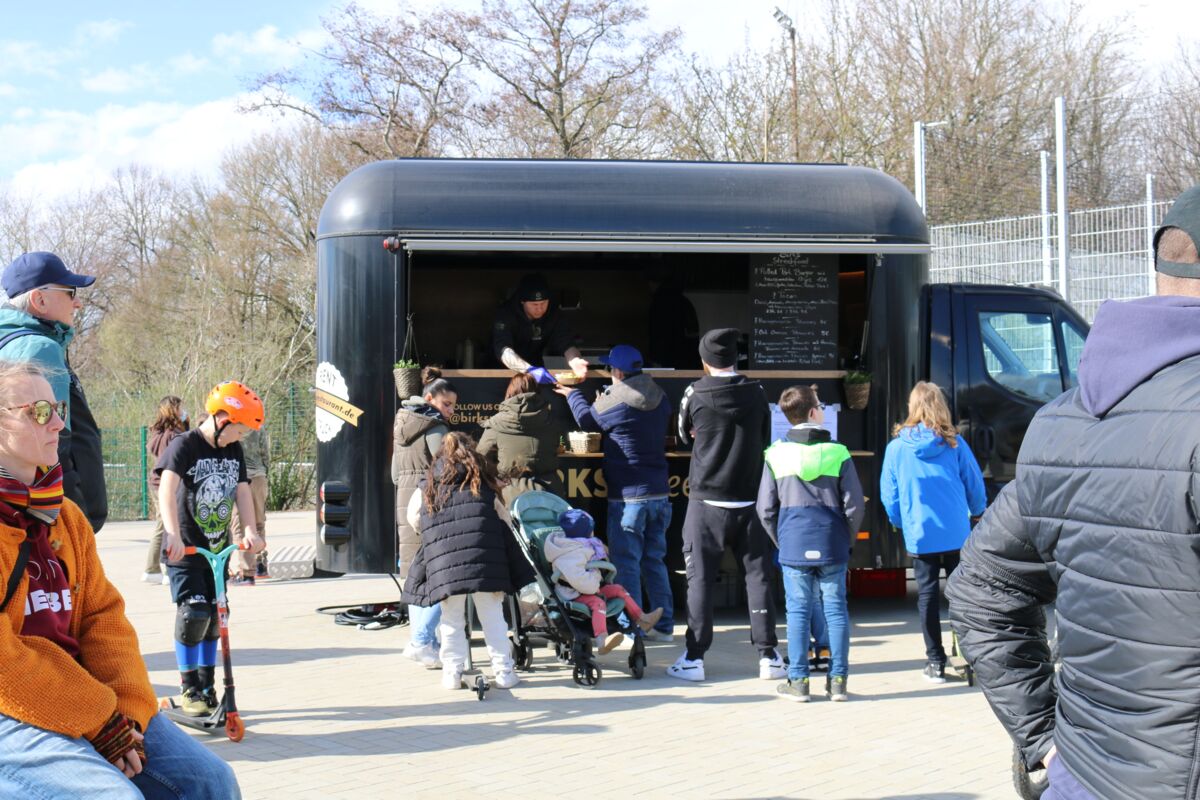 Mehrere Menschen stehen an einem Food-Truck an.